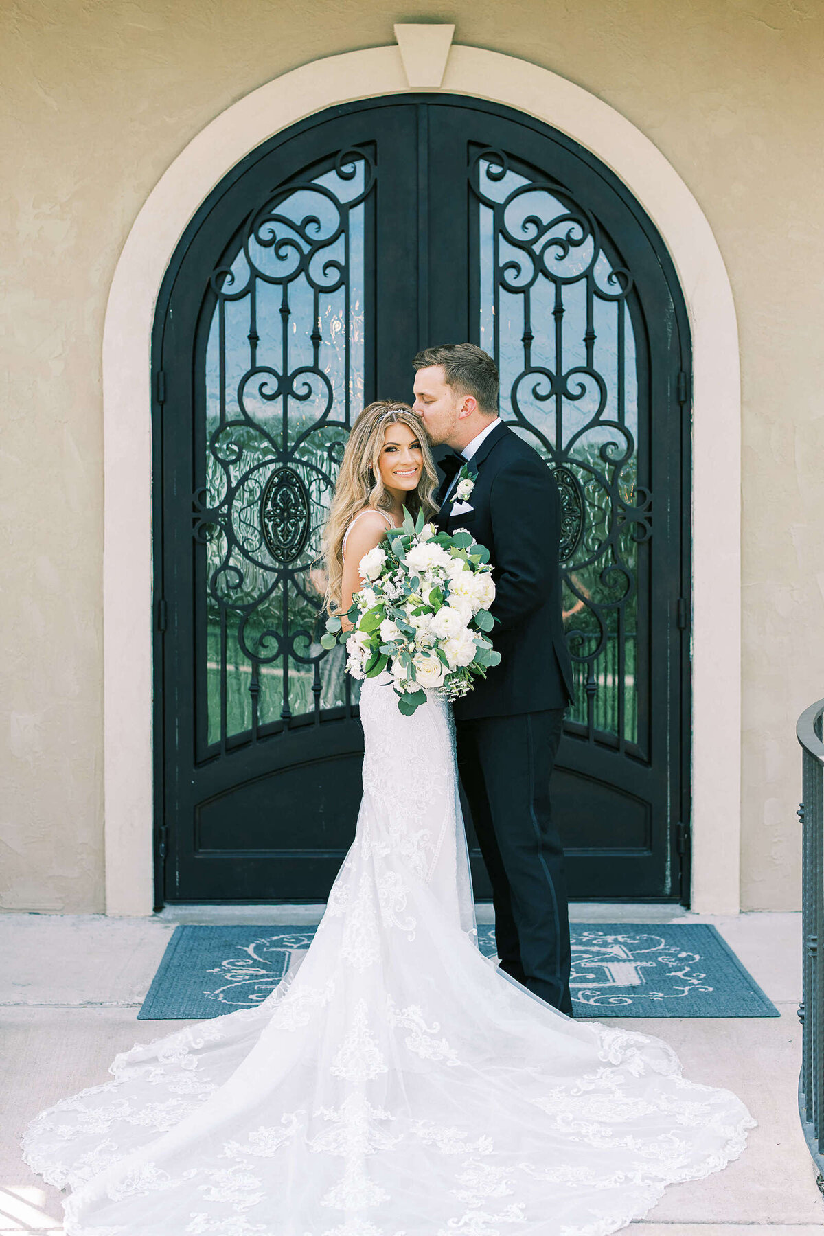 Bride and groom kiss outside of the wedding chapel at D'Vine Grace Vineyard in Texas