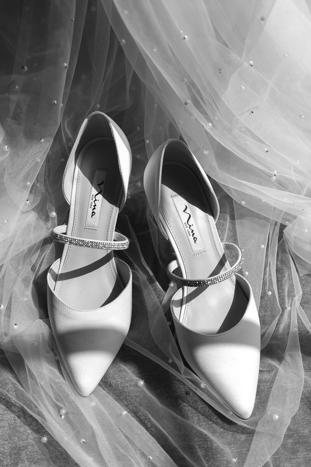 Beautiful light cascaded on the brides wedding shoes and pearled veil.