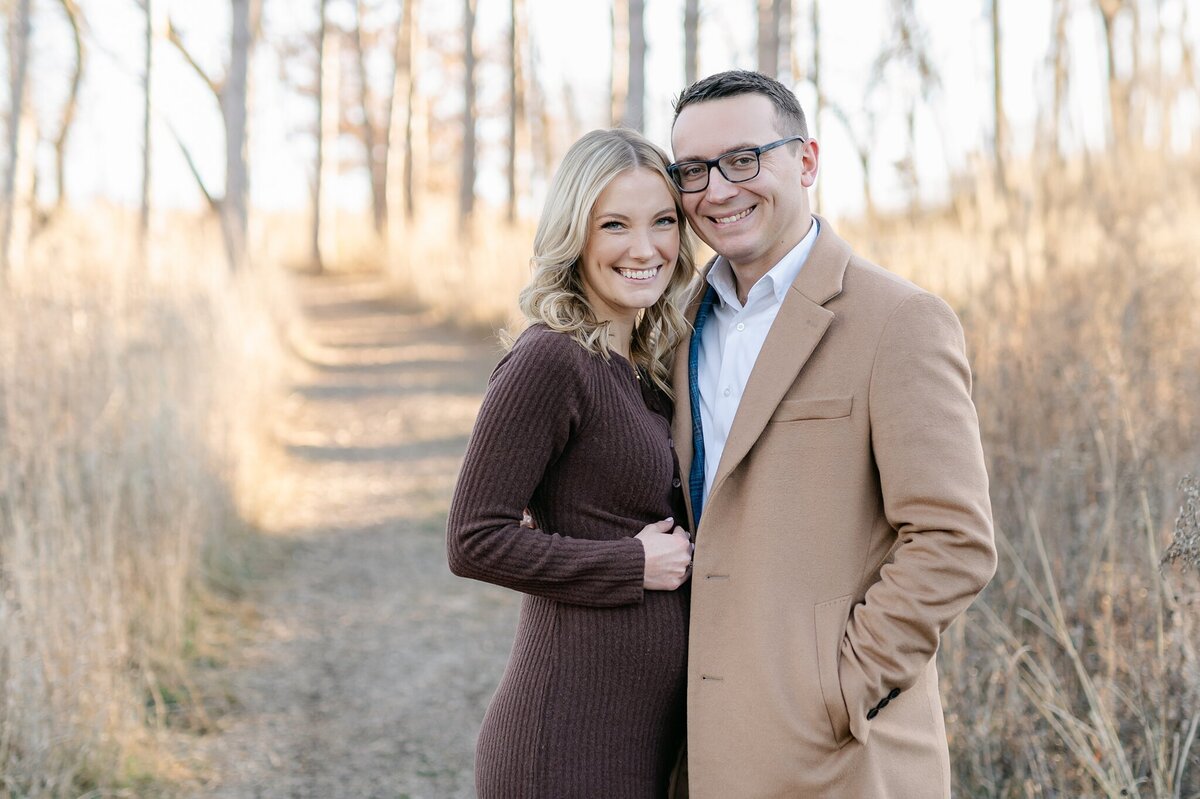 Portrait of two expecting parents smiling at the camera, taken by Abby Park Photography in Milwaukee