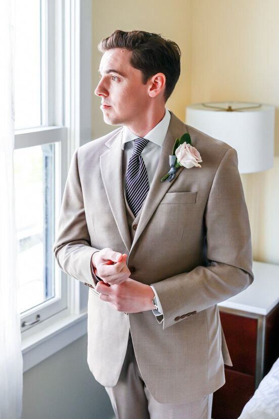 portrait-of-groom-looking-out-window