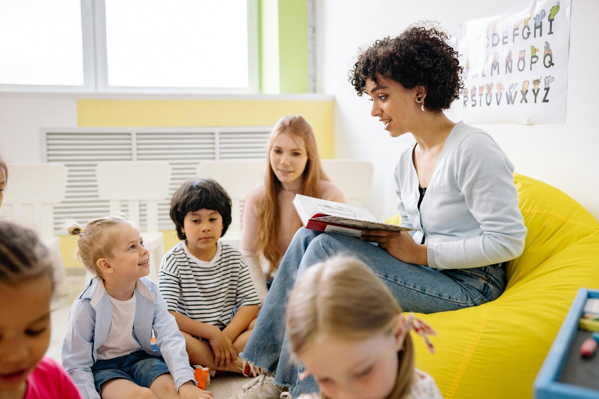 teacher reading to students sitting on the floor