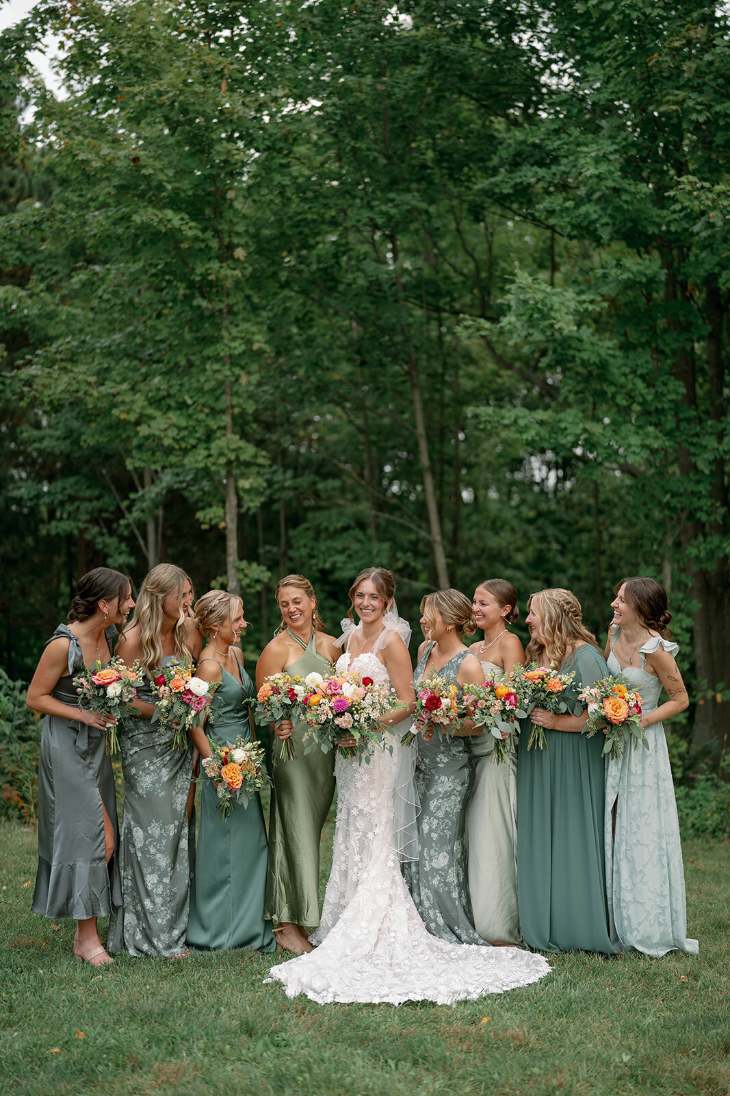 Bridesmaids smiling for a posed portrait during a fall wedding at The Cherry Barn in Frankfort MI.
