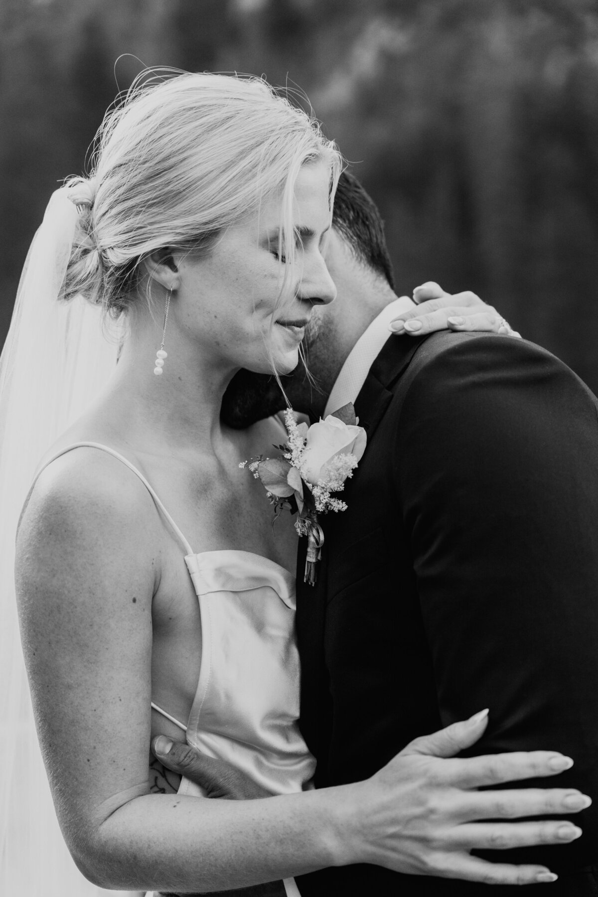 Bride closing eyes while hugging groom during quiet moment
