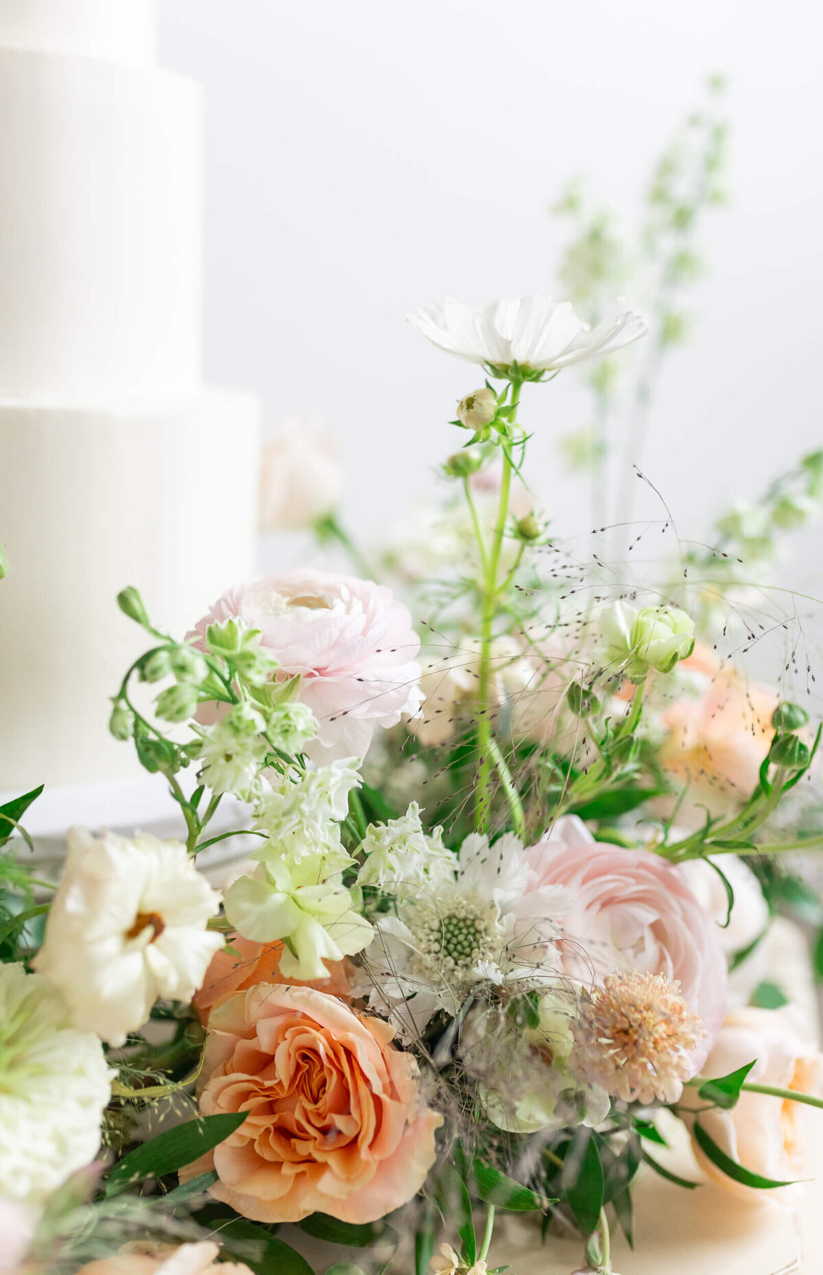 detail shot of flowers surrounding wedding cake