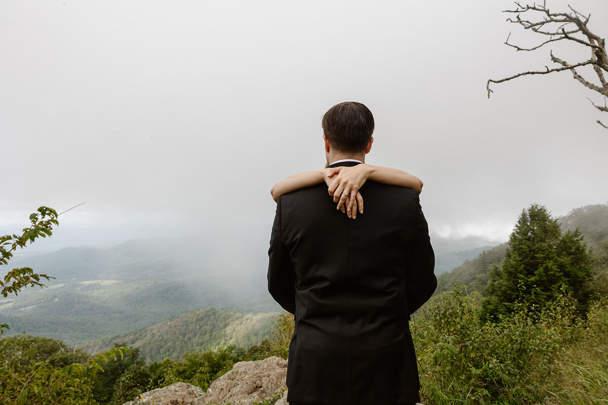 A person hugging their partner on an overlook