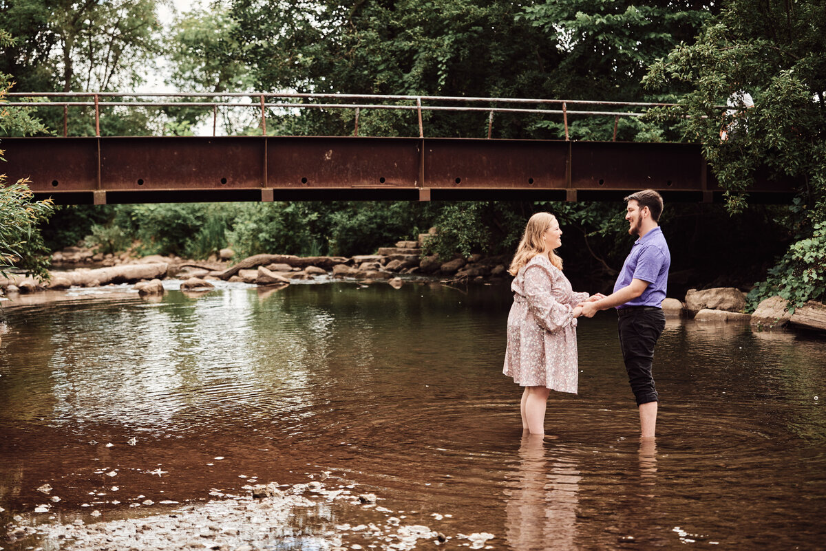 An Engagement session with a couple at Rochester Municipal Park. The couple stand in the creek enjoying the gaze between the two of them.