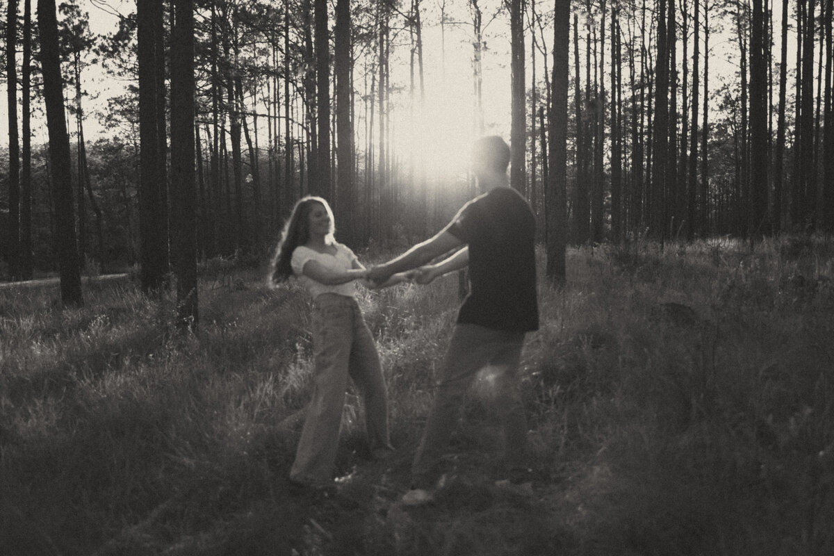 Couple posing for portraits in a forest.