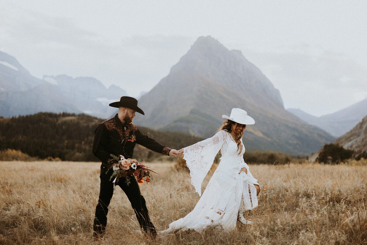 bride and groom sitting in a grass field