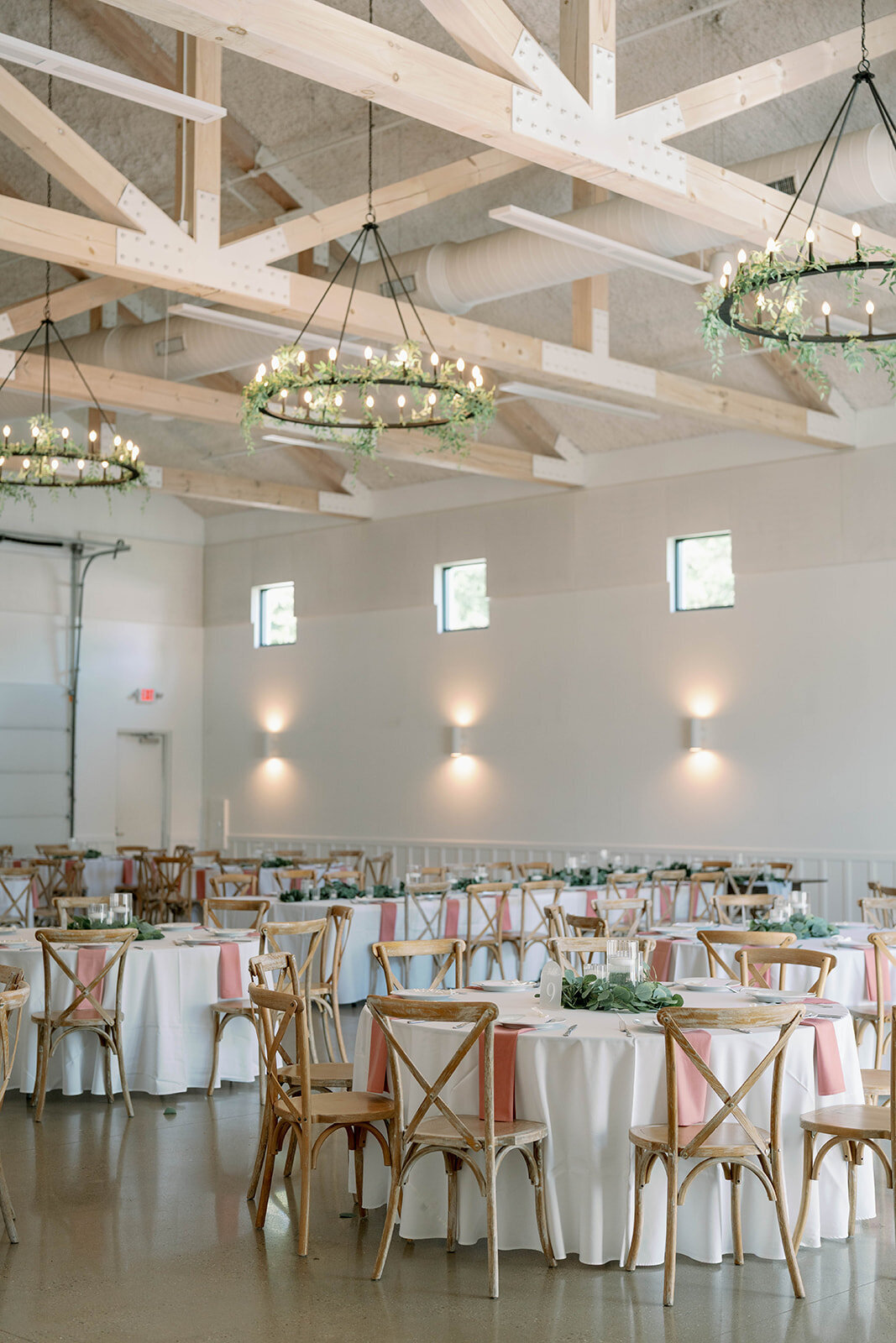 Wide shot of the Ivy House reception space showing elegant chandeliers and soft romantic décor.