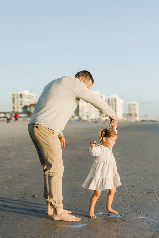 father-twirling-daughter-on-Coronado-beach-san-diego