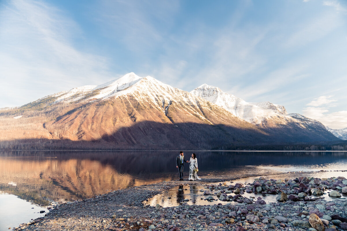 Bride and Groom walking by Lake McDonald.