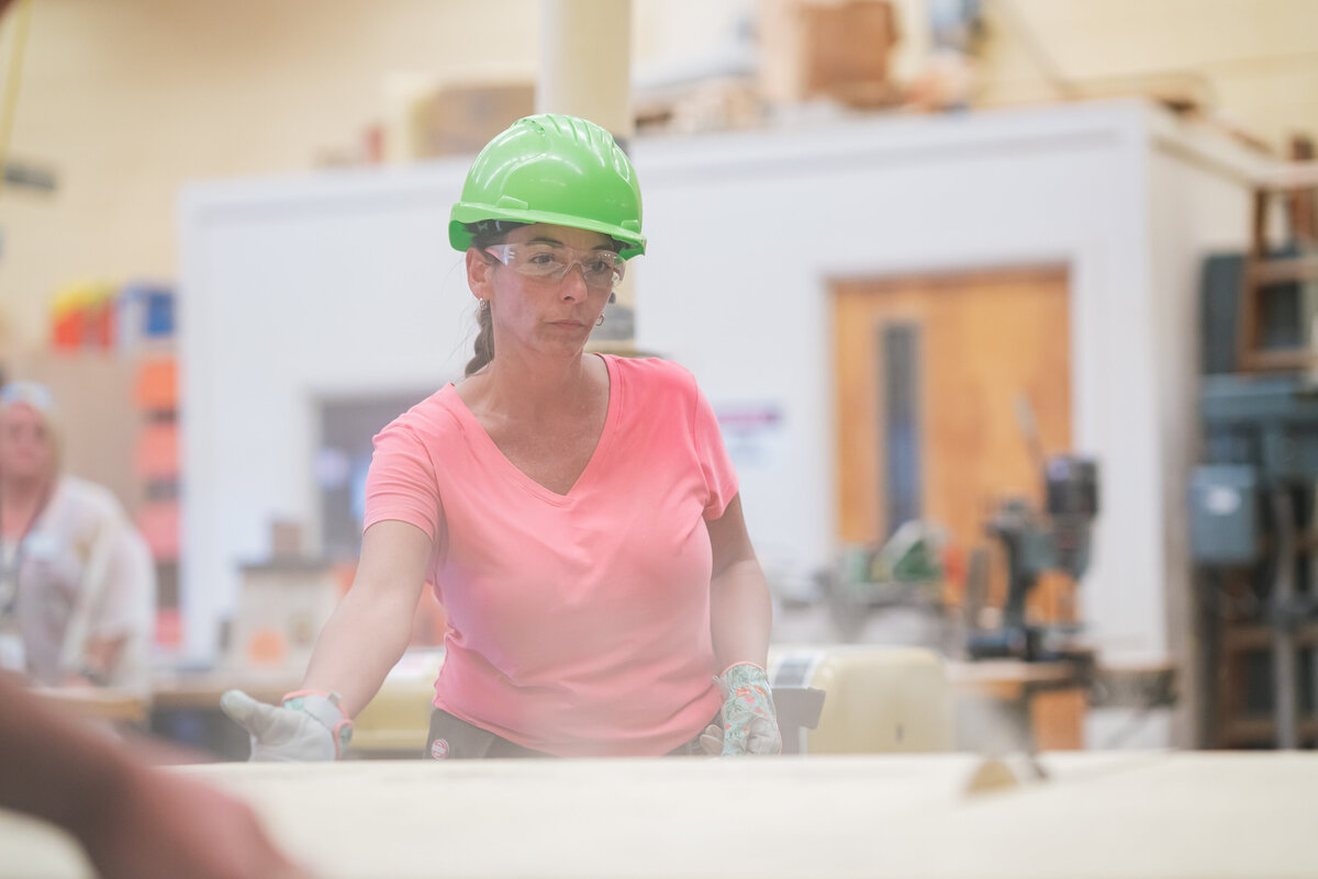 Female construction teacher cutting drywall