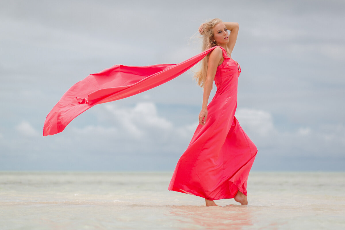 beautiful woman in pink dress on a sandbar