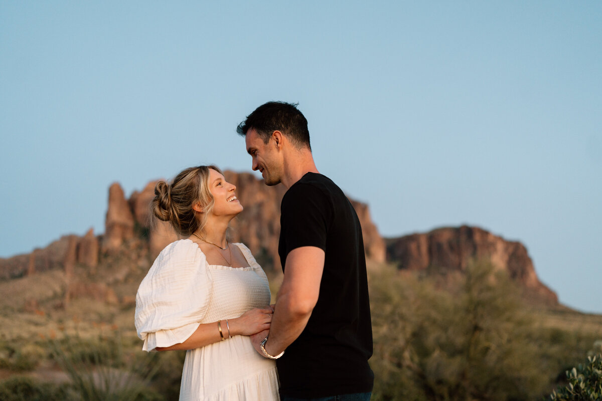 expecting couple pose in arizona landscape