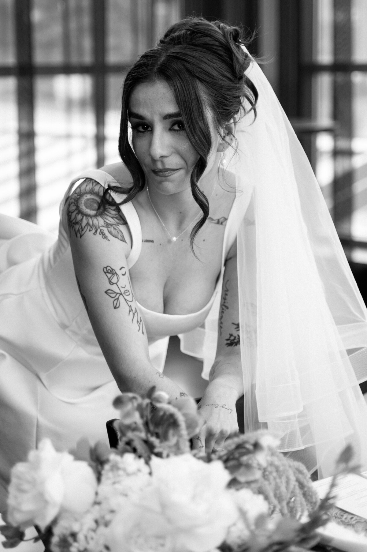 Soft bridal portrait taken indoors with floral arrangement and veil in Banff venue.
