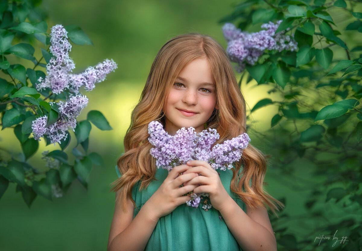 Red hair ginger Paisleigh smelling lilacs in the spring.