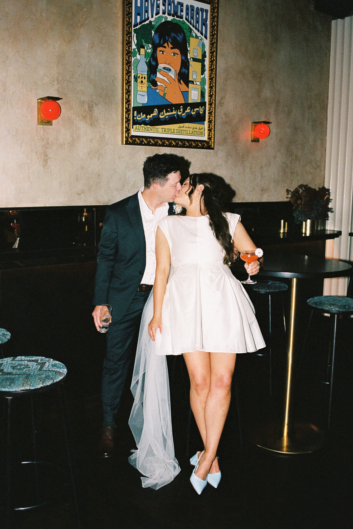 couple sharing a kiss at their Melbourne Jayda Bar wedding reception on 35 film