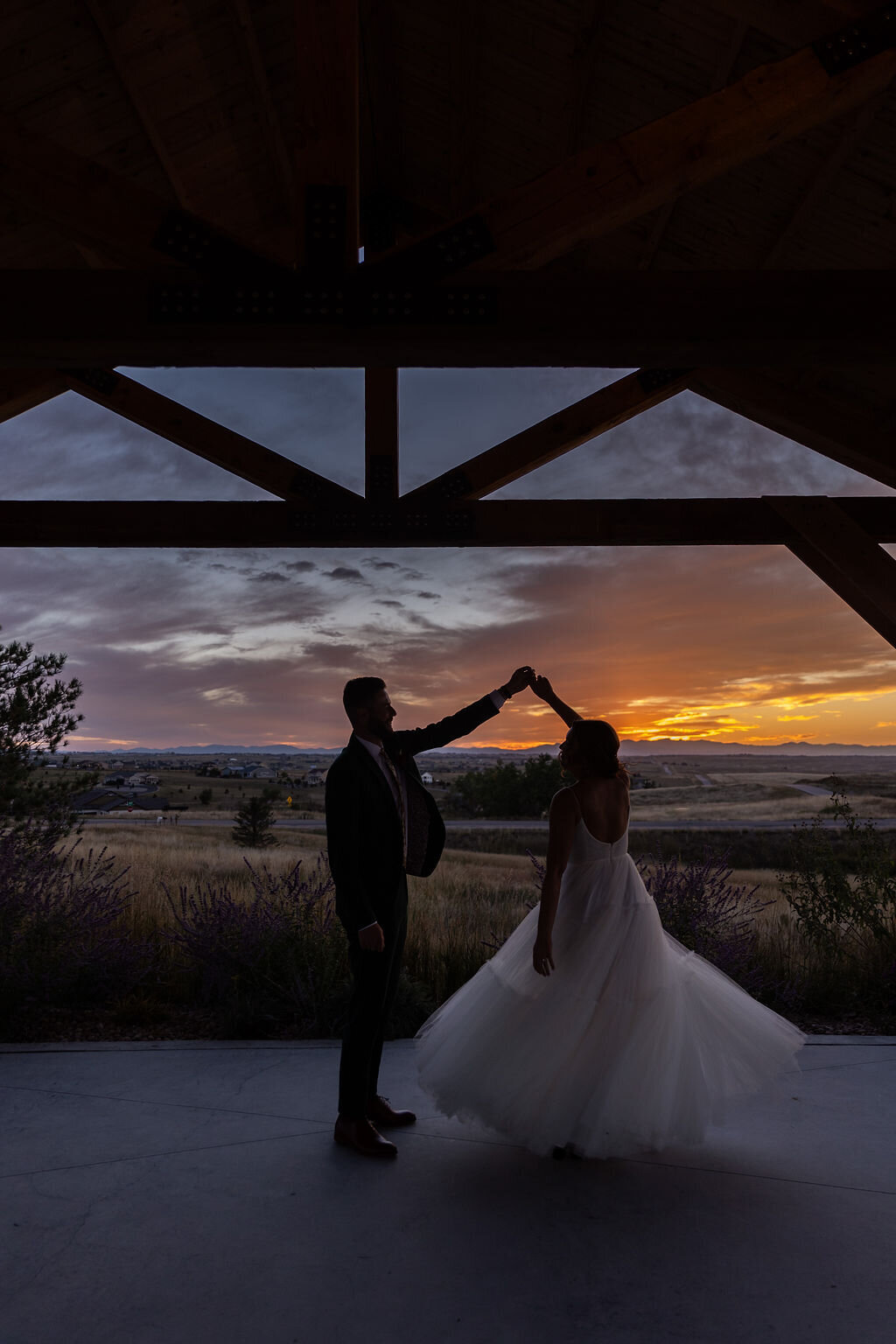 Bride and groom dance in front of the sunset after their wedding at Bonnie Blues Event Venue.
