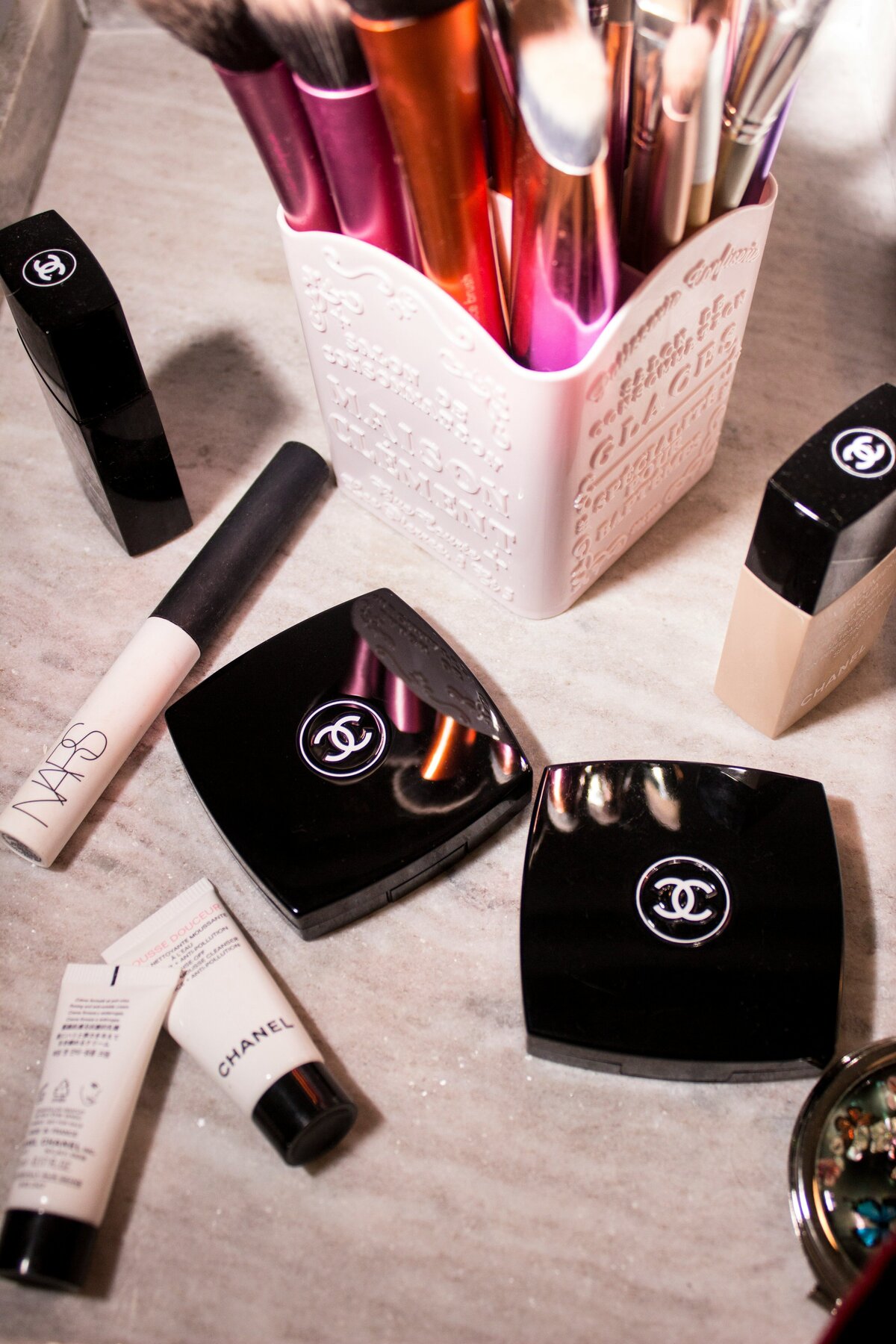 Flat lay photo of different makeup products laying on a table