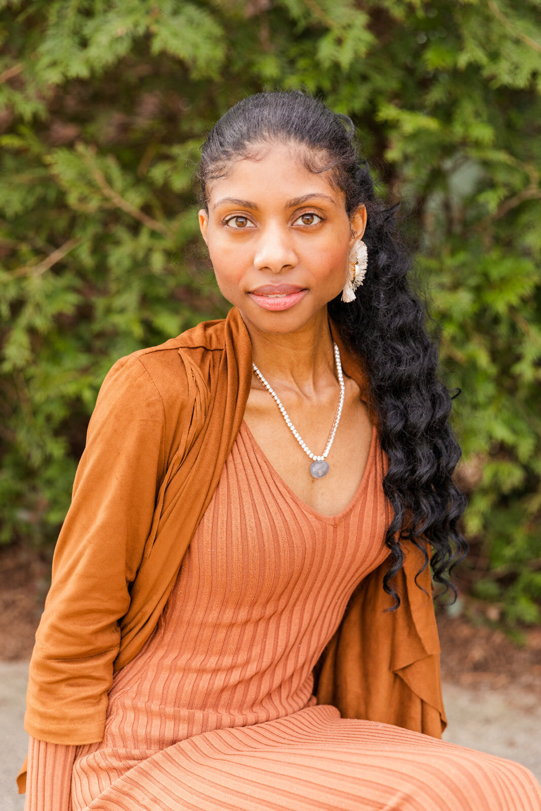 woman with long curly haire sitting in beige dress and beige jacket looking at the camera Carrie  Christie  Lawyer | Atlanta GA headshots Photographer | Laure branding Photography