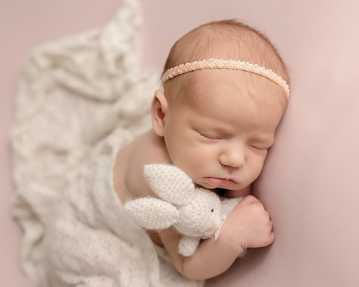 baby girl holding bunny with pink headband