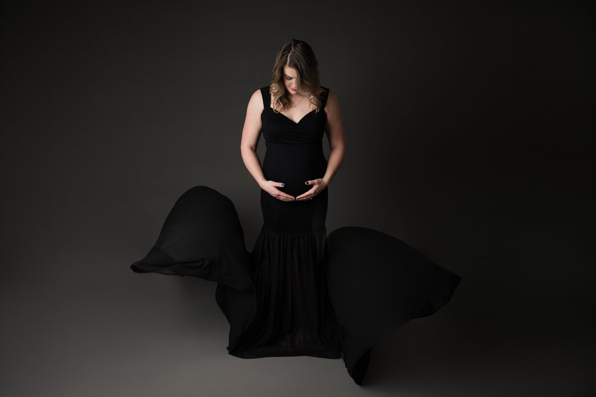 maternity photo with black flowing dress in studio