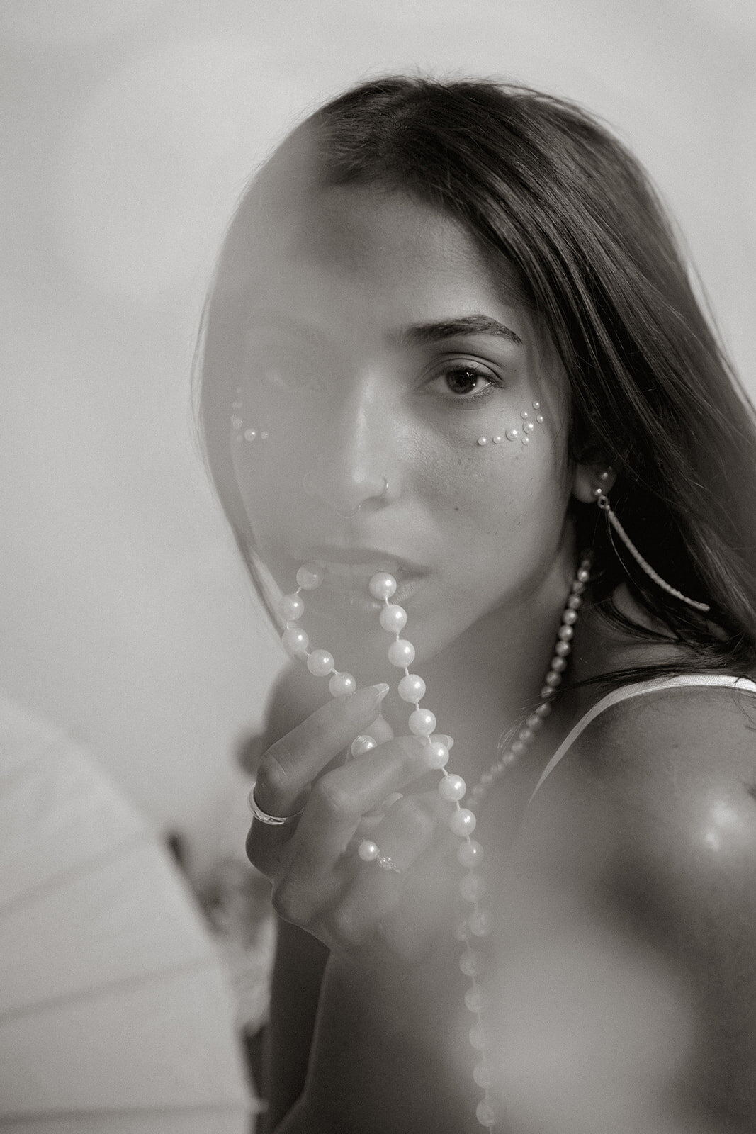 close up woman with pearls in mouth and face with pearl decorations