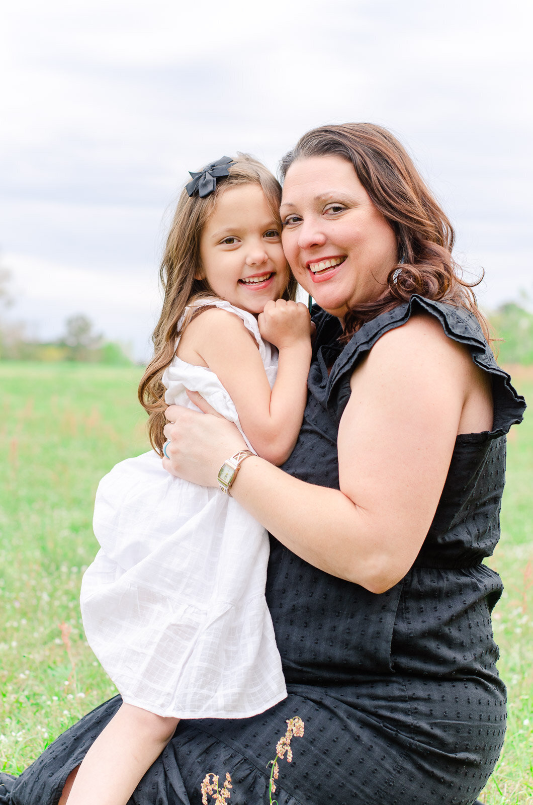 mother and daughter embrace in a field