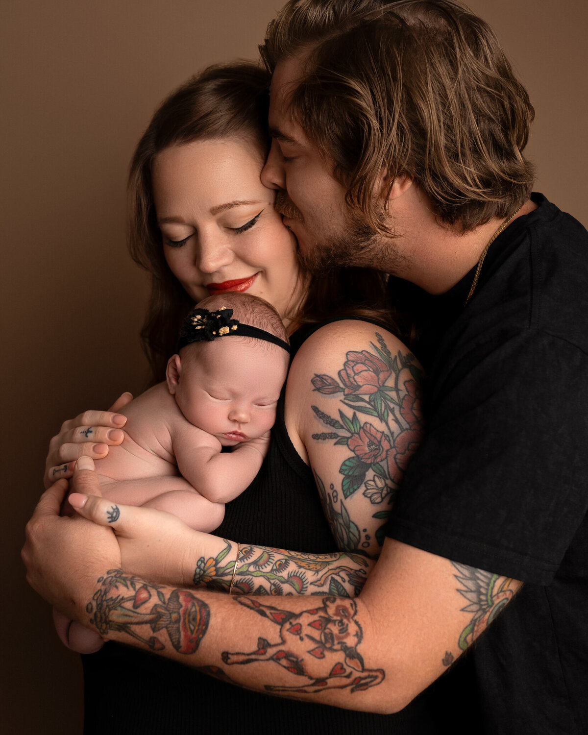 Newborn cradled in arms of tattooed parents during emotional studio portrait | Austin newborn photographer serving Kyle and Cedar Park
