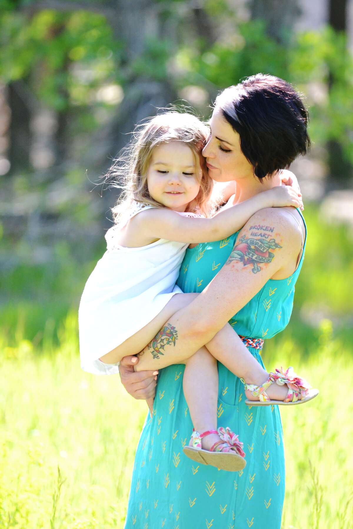 mom-holding-daughter-in-grassy-area