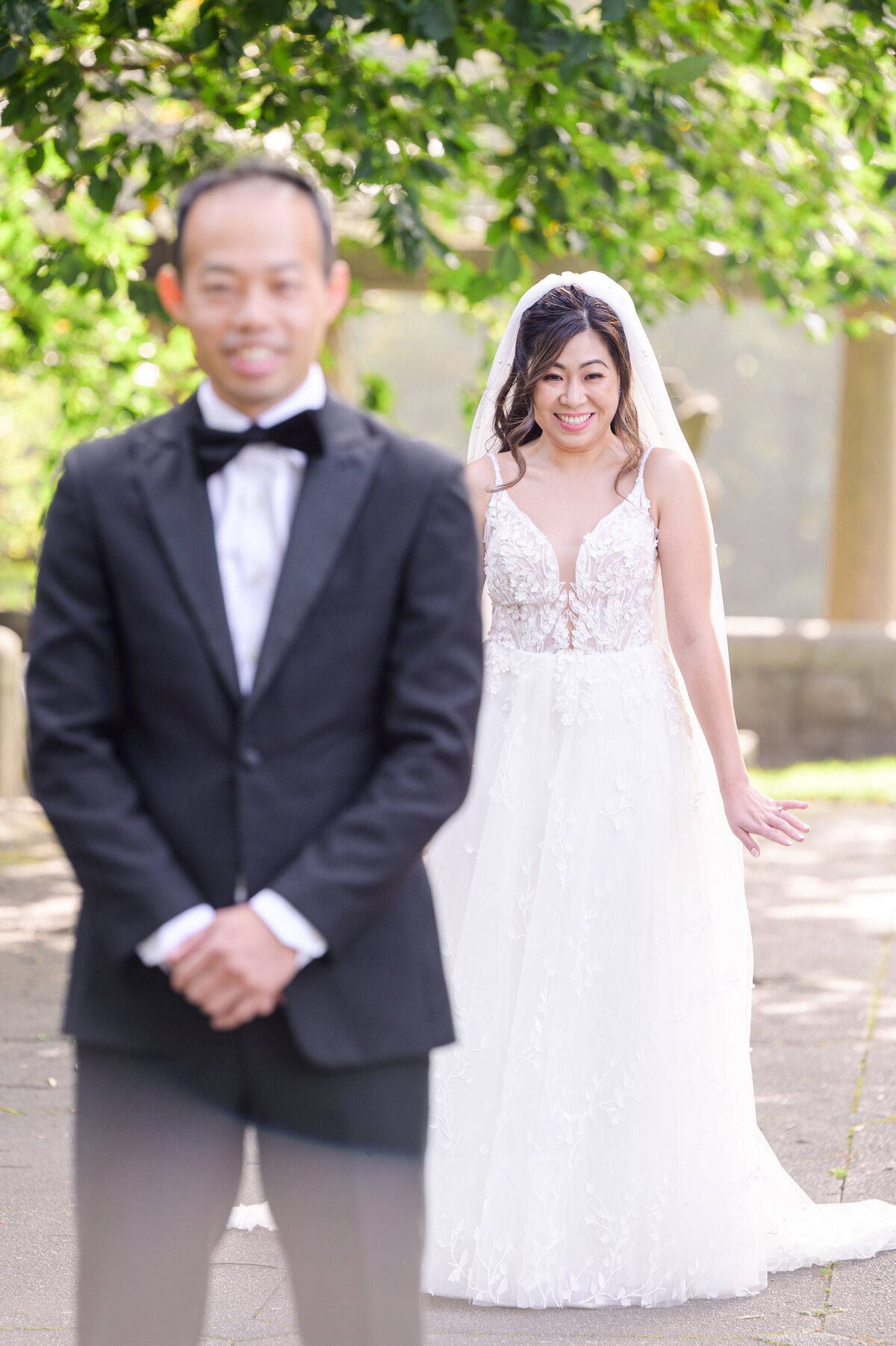 Bride standing behind the groom before the first look representing candid Boston wedding photography