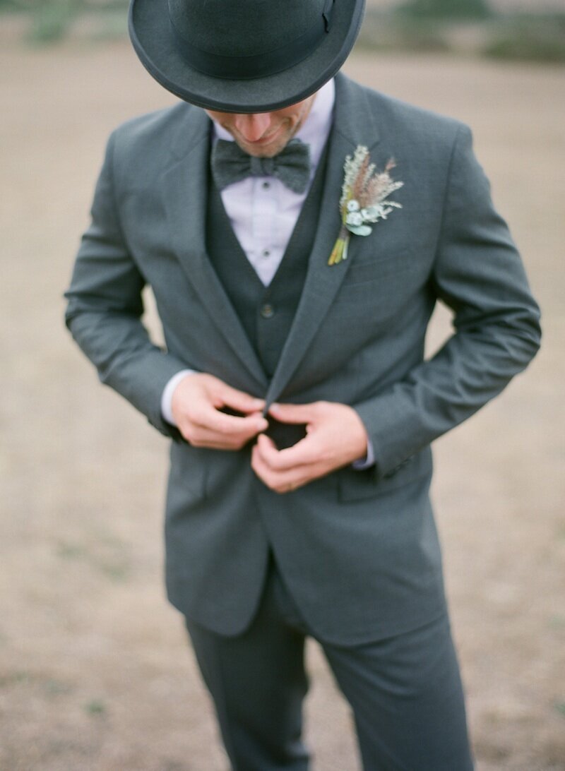 groom in a gray suit and hat