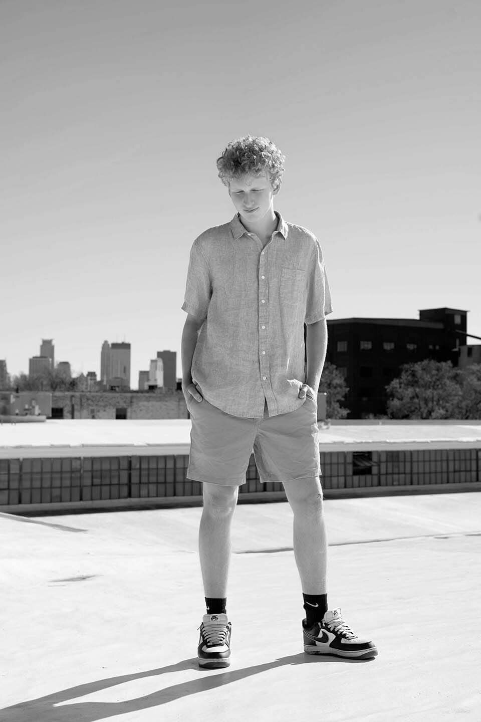 highschool-senior-boy-on-rooftop-overlooking-city