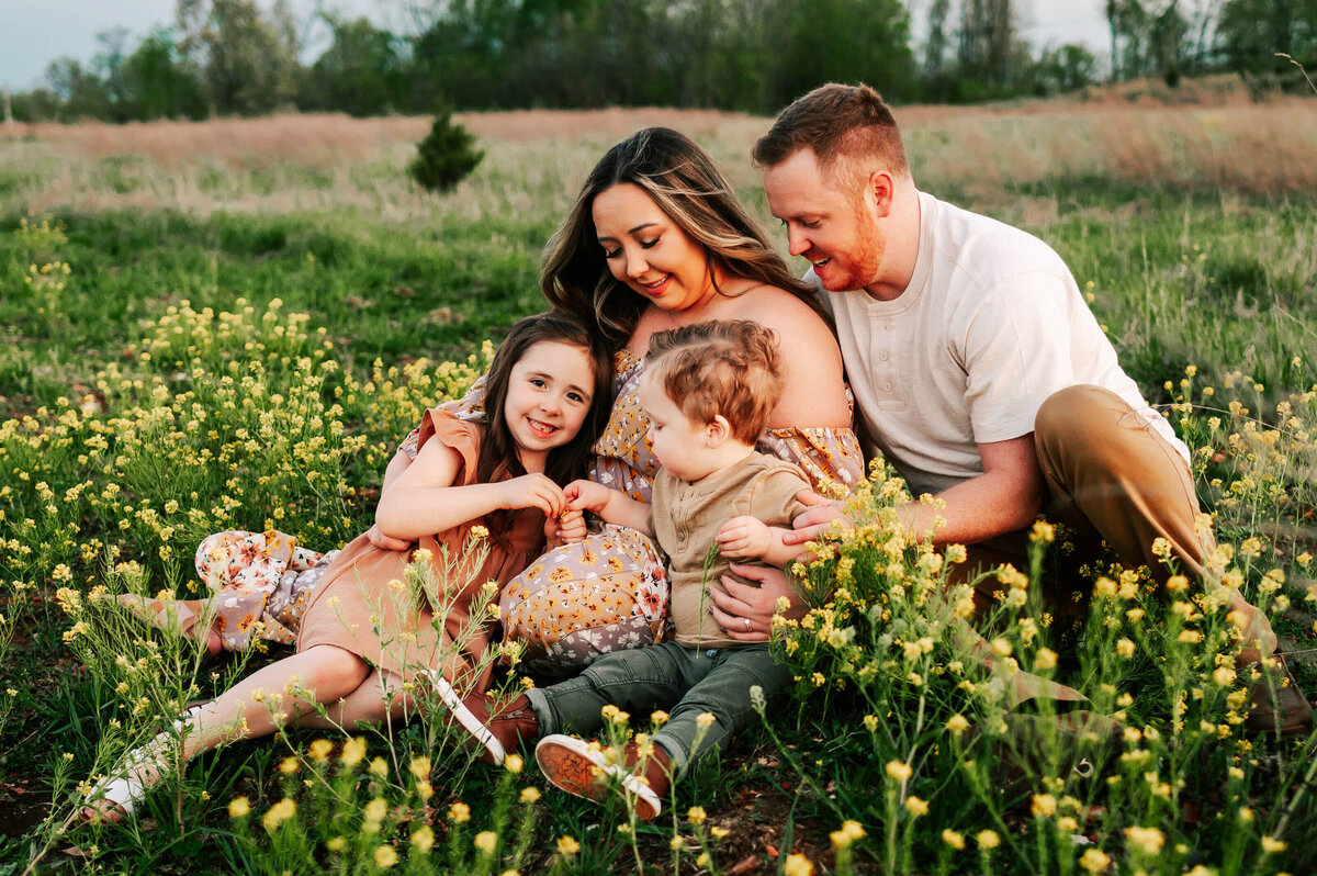 family cuddling in flower field enjoying Branson MO family photography