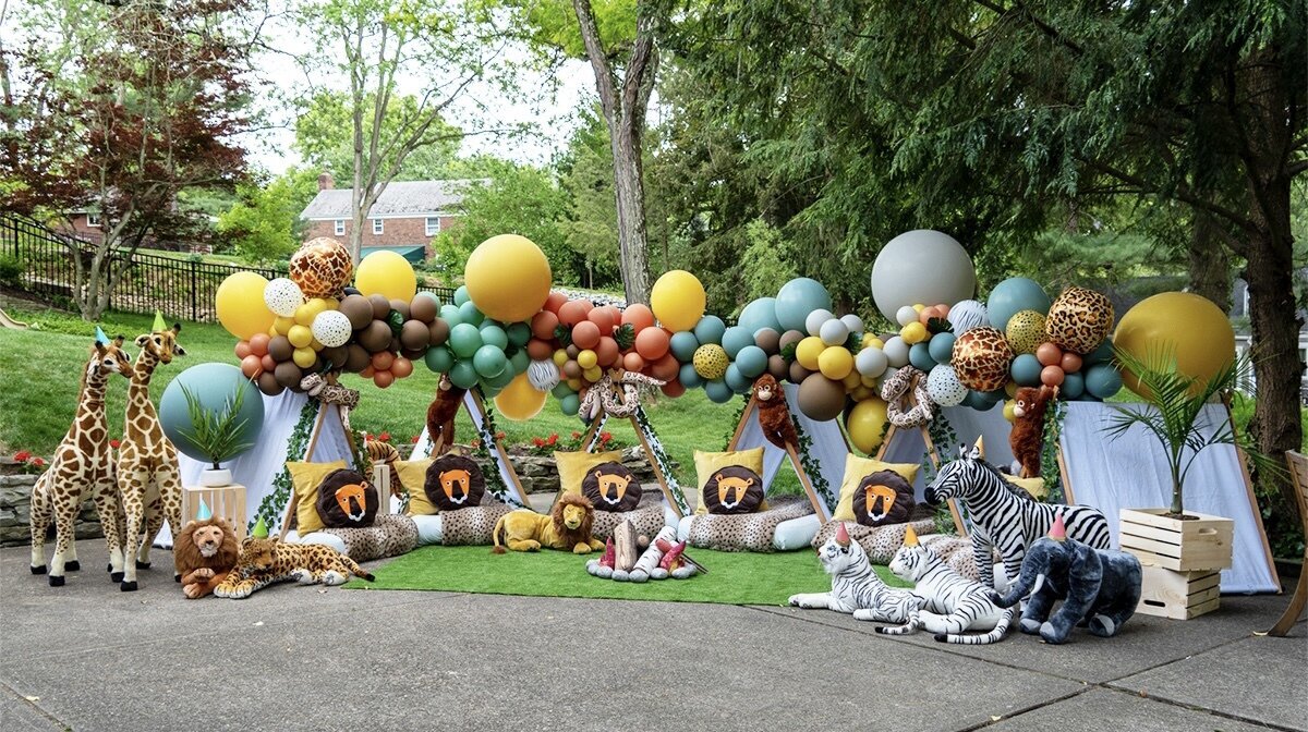 safari themed tent party set up with balloons and stuffed animals