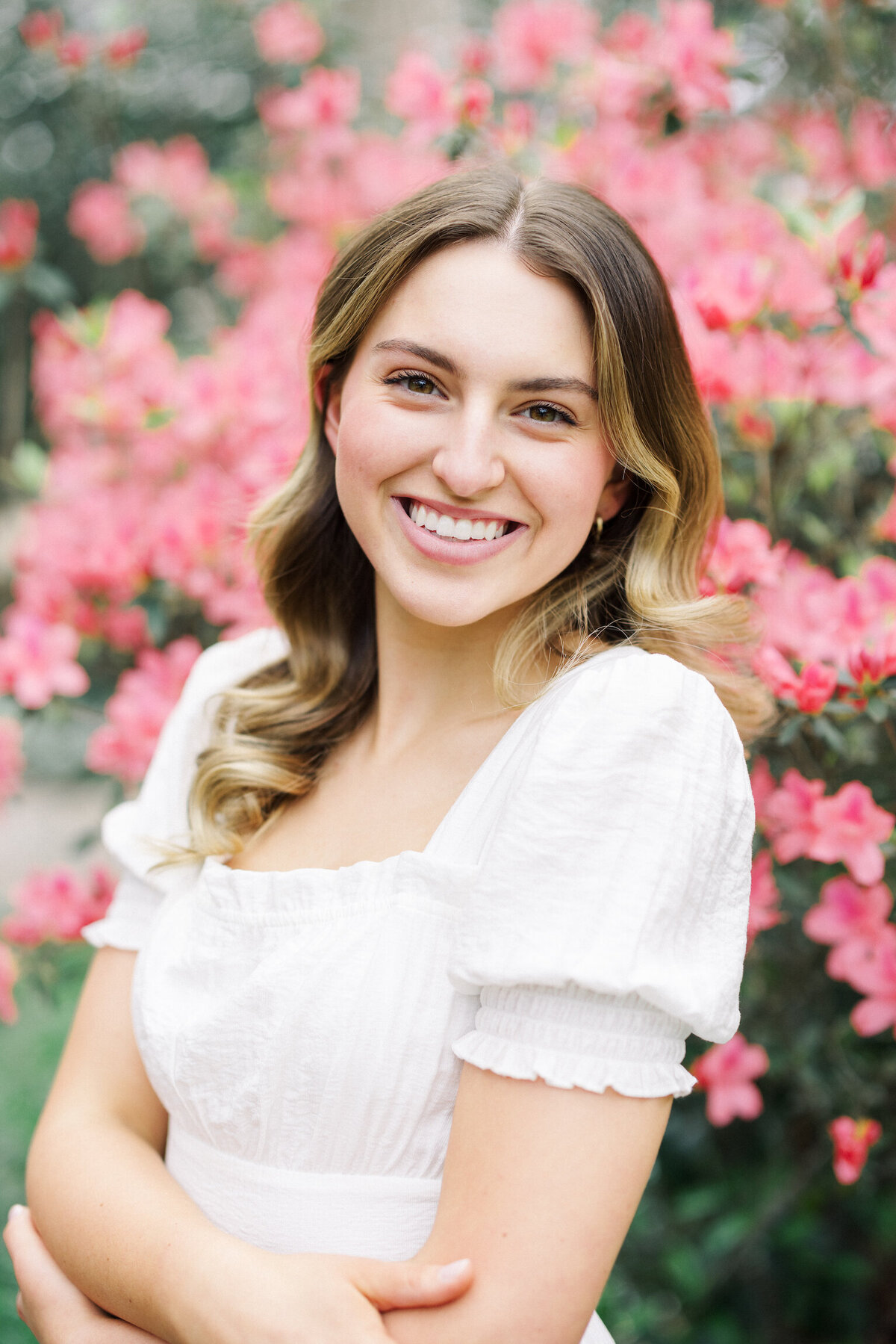 A beautiful senior portrait set among the lush greenery and flowers of the UL Alumni Center Gardens, capturing elegance and personality on film by Morgan Alysse, Louisiana film photographer.
