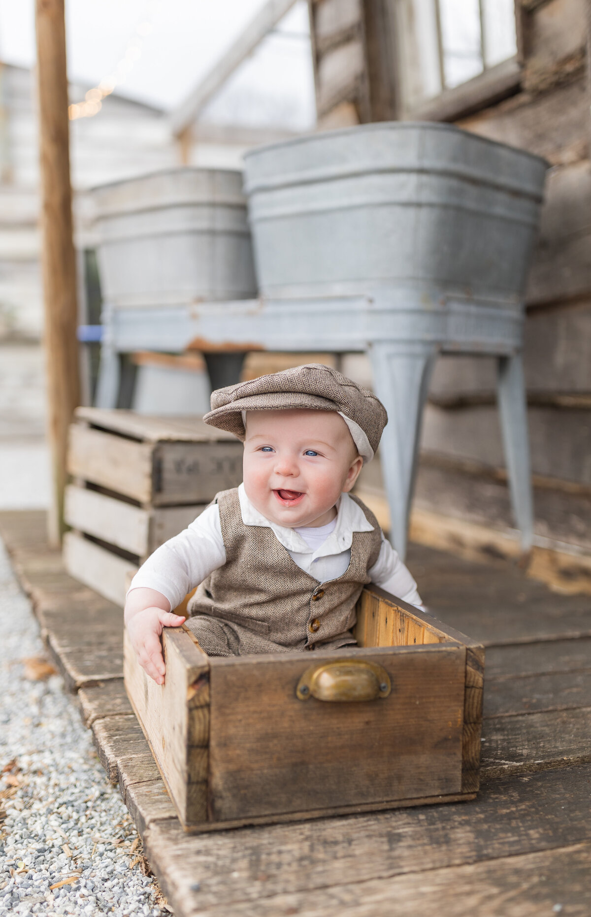 Frozen Moments by Kathy Photography | little boy in crate on a wood front porch