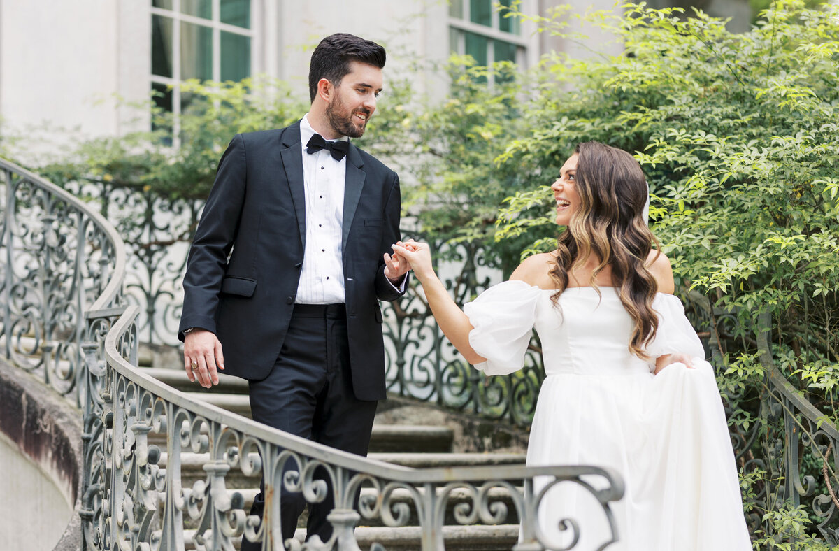 bride and groom walking down the stairs holding hands