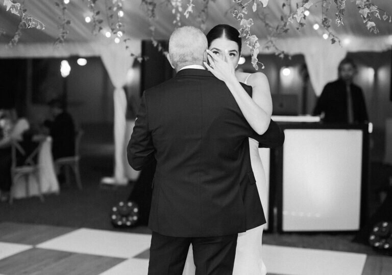  A touching black-and-white image of the bride and her father embracing on the dance floor, a sentimental wedding day moment captured in timeless photography. Florida Keys wedding photography by Claudia Amalia Photography.