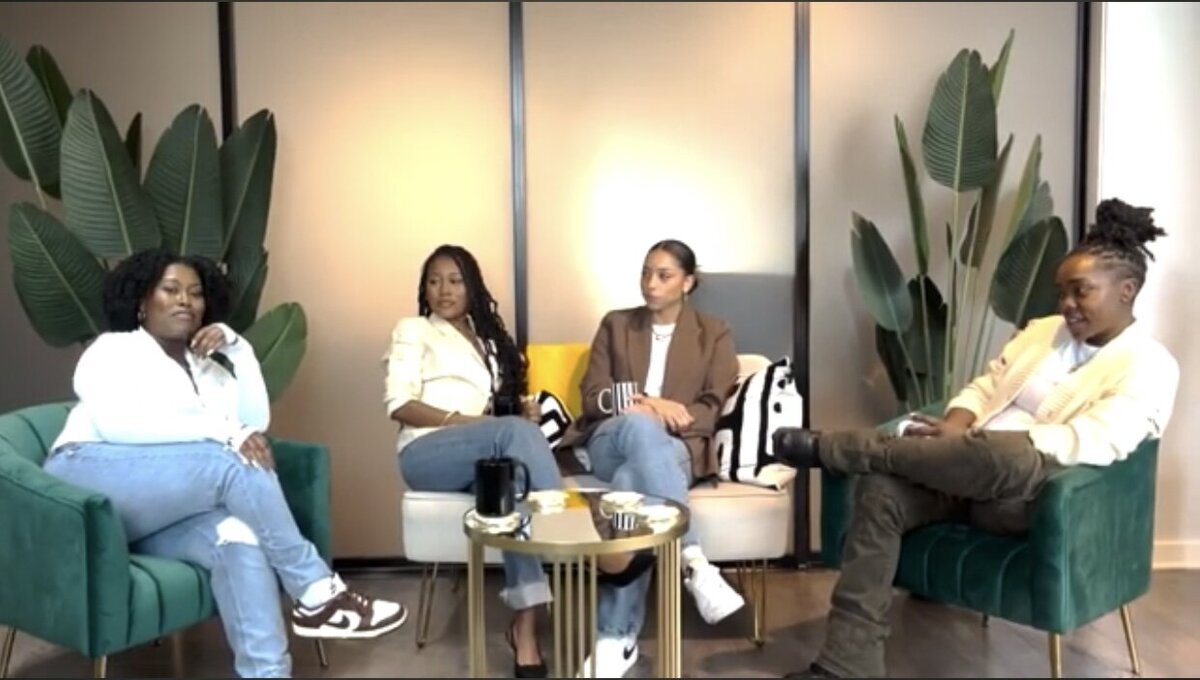 Still image of women sitting in discussion