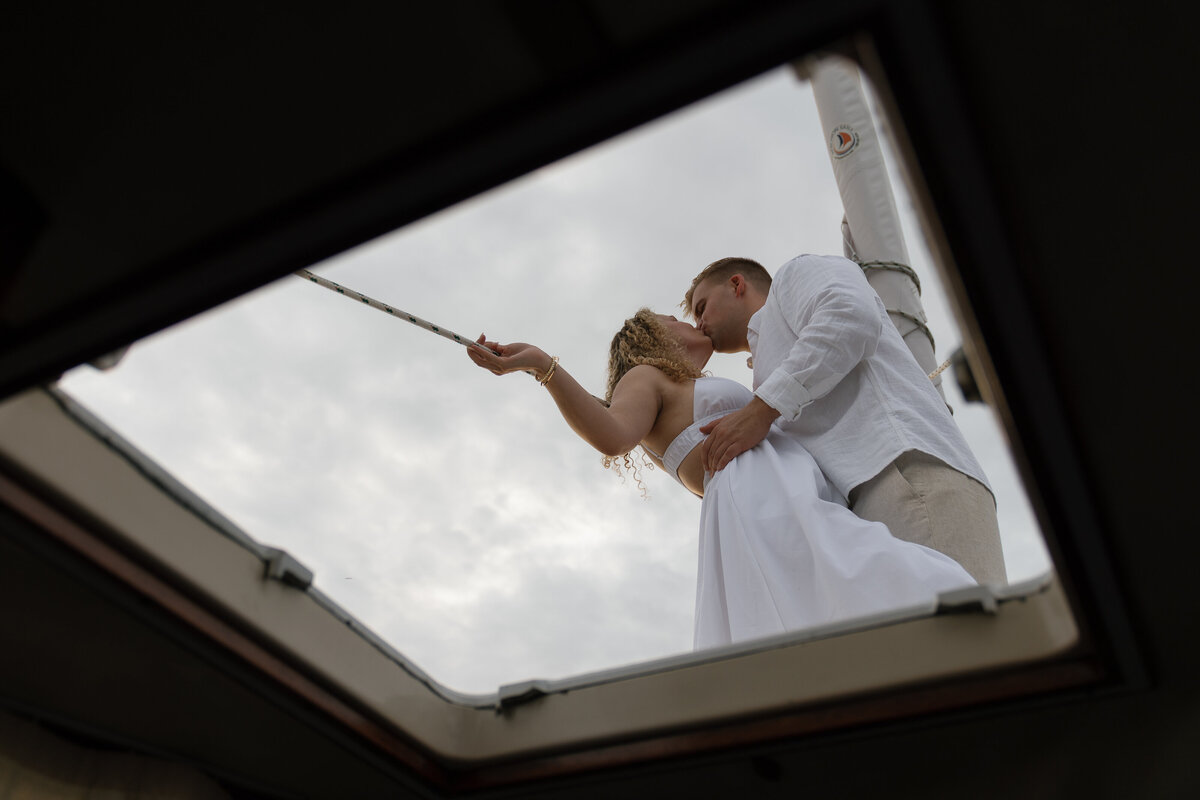 Couple kissing on a sailboat for engagement photography florida, by Shelby Ann Photos