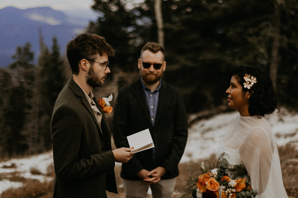 bride and groom exchanging vows and rings on the Sandia Mountains