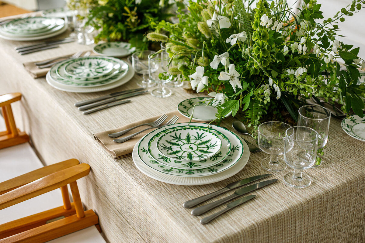 Sultan's Garden green and white china featuring illustrations of gazelles, lions, and monkeys playing beneath palm and cypress tress, used on wedding reception table
