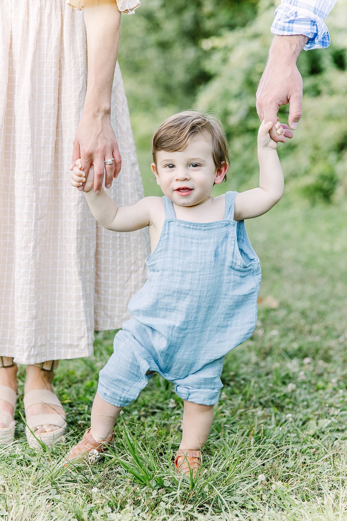 son holds moms hand duirng summer  family photo session with Sara Sniderman Photography in Natick Massachusetts