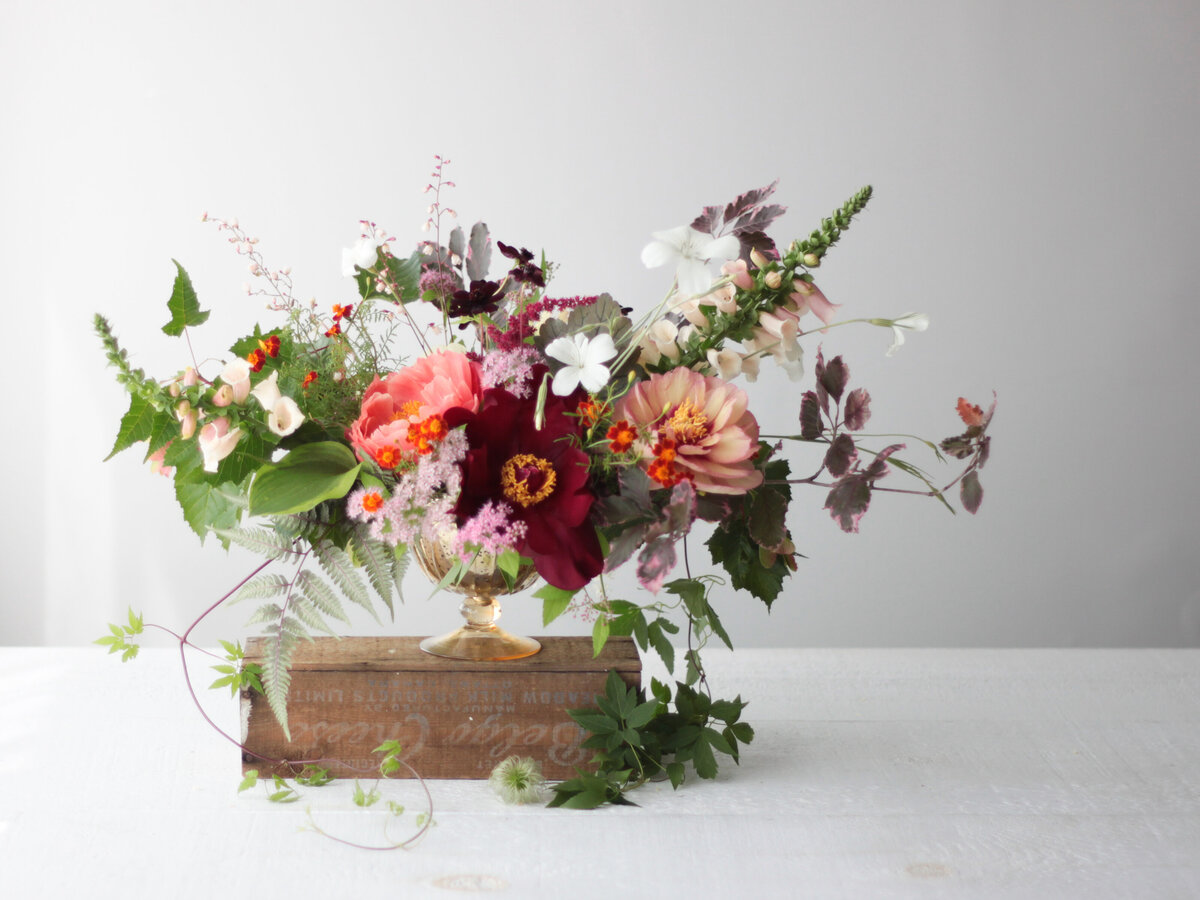 Lush springtime garden flowers with cascading greenery in an arrangement for a Montreal wedding.