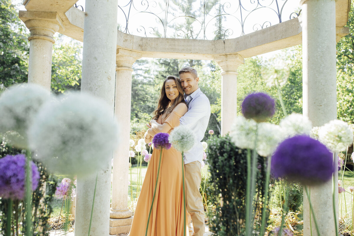 Couple hugging among white and purple flowers at Sayen House and Gardens in Hamilton Township Mercer County New Jersey