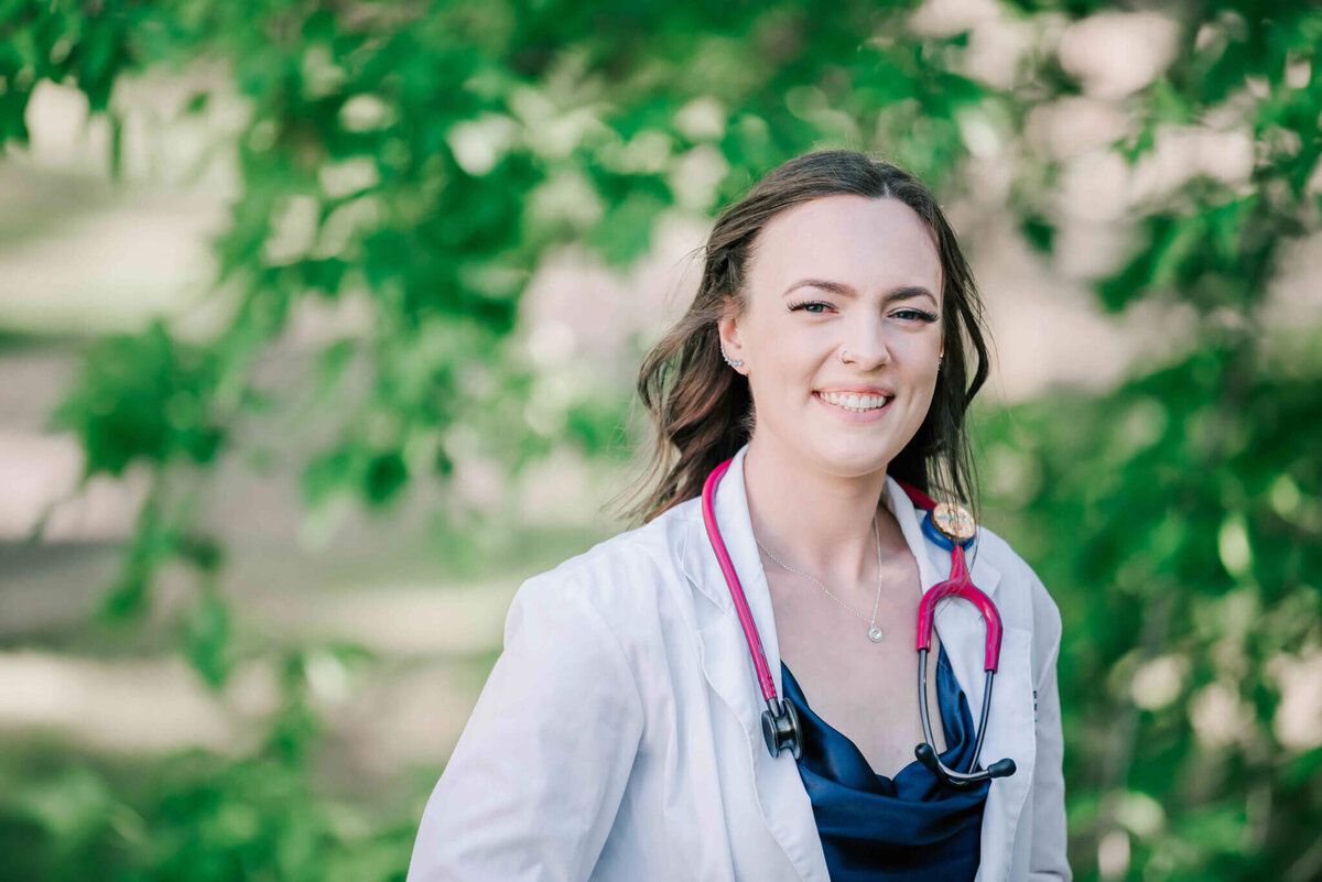 Wearing her nursing white coat and stethoscope.  