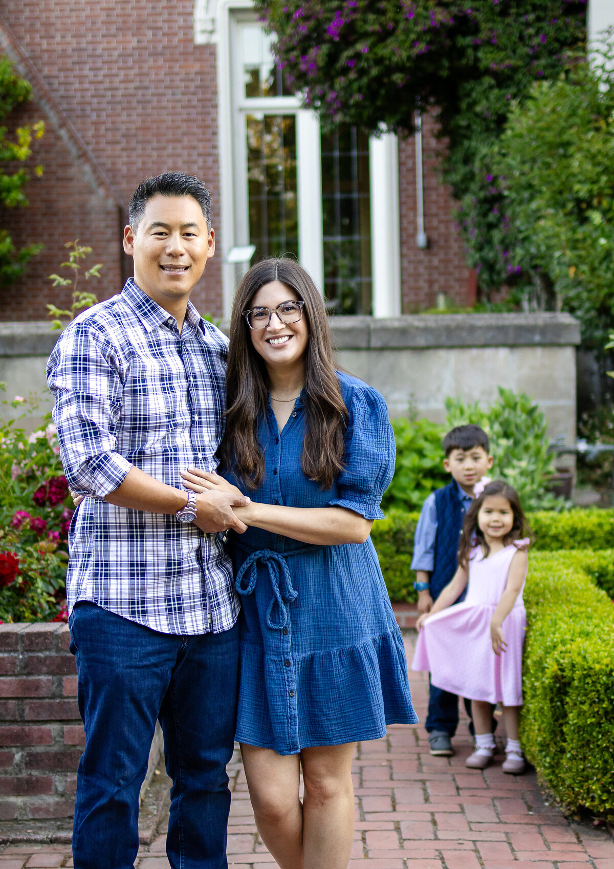 Family of four in a blooming rose garden, surrounded by lush hedges – lifestyle family photography by Ellobelle Photography, San Francisco Peninsula kohl mansion Burlingame