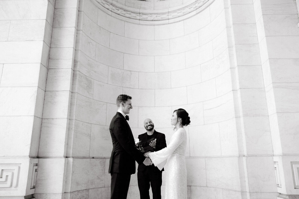 The bride and the groom are happily saying their vows in the New York Public Library. Image by Jenny Fu Studio