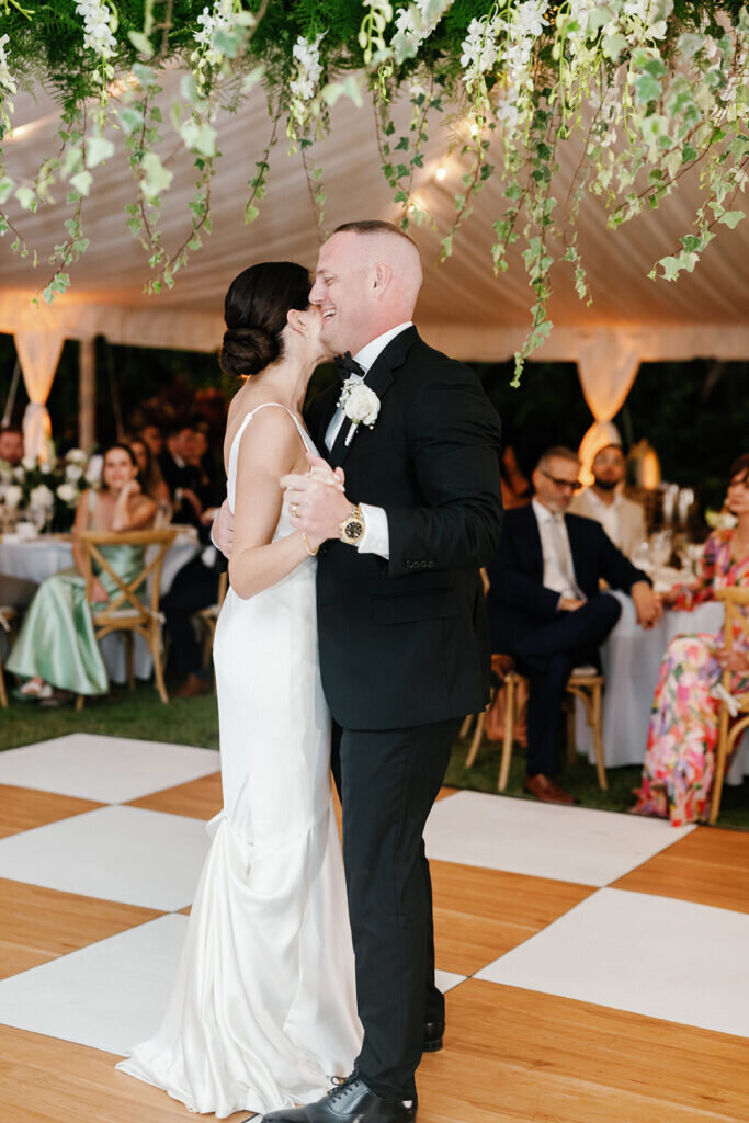 A joyful wedding reception moment as the bride and groom share a lighthearted dance, their happiness radiating through the celebration. Captured by Claudia Amalia Photography.